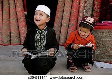 Two local children in front of a rug store, Yengisar, Xinjiang Province, China View Large Photo Image Picture - Two local children in front of a rug store, Yengisar, Xinjiang Province, China. Fotosearch