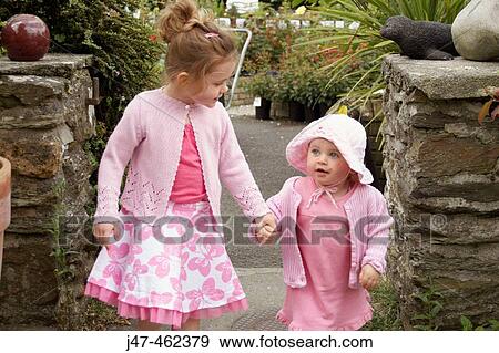 Two lttle girls walking together holding hands View Large Photo Image Stock Photo - Two lttle girls walking together holding hands. Fotosearch