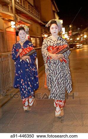 Two? Maiko? (geisha apprentices) walking to their evening appointment in the traditional quarter of Gion. Kyoto. Kansai, Japan (Model Release) View Large Photo Image Stock Image - Two? Maiko? (geisha apprentices) walking to their evening appointment in the traditional quarter of Gion. Kyoto. Kansai, Japan (Model Release). Fotosearch