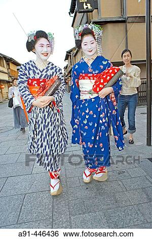 Stock Photograph - Two? Maiko? (geisha apprentices) walking to their evening appointment in the traditional quarter of Gion. Kyoto. Kansai, Japan (Model Release). Fotosearch