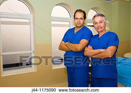Stock Image - Two male plastic surgeons in surgery room, West Palm Beach, Florida, USA. Fotosearch