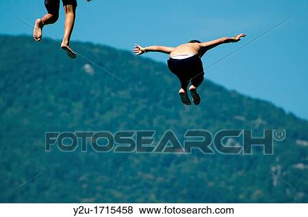 Two man jumping from a diving board View Large Photo Image Stock Photo - Two man jumping from a diving board. Fotosearch