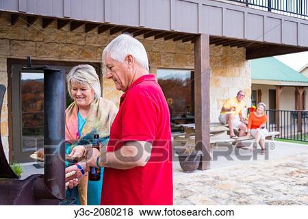 Two married couples, retired, having a backyard barbecue. 2 women, 2 men, all around 60 years old, caucasian ethnicity. View Large Photo Image Stock Photo - Two married couples, retired, having a backyard barbecue. 2 women, 2 men, all around 60 years old, caucasian ethnicity.. Fotosearch