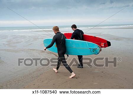 Two men carrying their surfoards, Borth, Ceredigion, West Wales UK View Large Photo Image Stock Image - Two men carrying their surfoards, Borth, Ceredigion, West Wales UK. Fotosearch