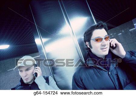 Two men talking on cell phones View Large Photo Image Picture - Two men talking on cell phones. Fotosearch