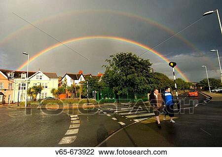 Two men walking across a zebra crossing with a dark cloudy sky with double rainbows over Aberystwyth town, Ceredigion, West Wales, May 2007 View Large Photo Image Stock Image - Two men walking across a zebra crossing with a dark cloudy sky with double rainbows over Aberystwyth town, Ceredigion, West Wales, May 2007. Fotosearch