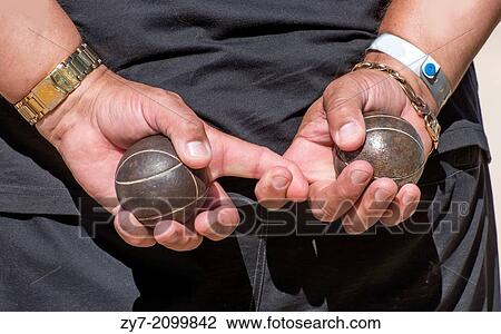 Stock Image - Two metal balls for game in p? tanque in man's hands.. Fotosearch