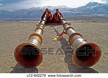 two monks playing the long tibetan Ragdun - horn on the roof of the Garze monastery, Sichuan, China View Large Photo Image Stock Photo - two monks playing the long tibetan Ragdun - horn on the roof of the Garze monastery, Sichuan, China. Fotosearch