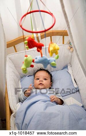 Two months old boy lying in his cot View Large Photo Image Stock Photo - Two months old boy lying in his cot. Fotosearch