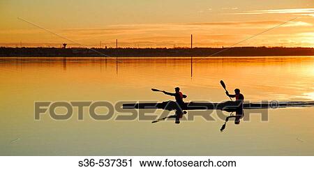 Two paddelers kayaking on Struer bay, Limfjorden, western Jutland, Denmark. Sunset and golden colors. View Large Photo Image Stock Image - Two paddelers kayaking on Struer bay, Limfjorden, western Jutland, Denmark. Sunset and golden colors.. Fotosearch
