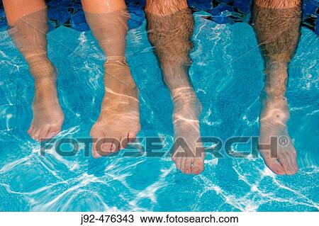 Two people sitting by edge of swimming pool View Large Photo Image Stock Image - Two people sitting by edge of swimming pool. Fotosearch
