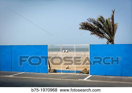 Two people, sitting on a wall, watching the sea on the beach in Essaouira Morocco, Africa View Large Photo Image Stock Photo - Two people, sitting on a wall, watching the sea on the beach in Essaouira Morocco, Africa. Fotosearch