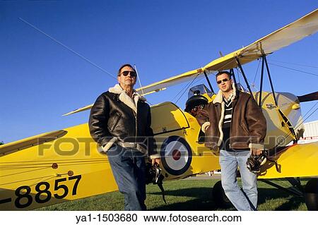 Two pilots with flying jackets near old British trainer biplane De Havilland DH 82a Tiger Moth used by the Royal Air Force View Large Photo Image Stock Image - Two pilots with flying jackets near old British trainer biplane De Havilland DH 82a Tiger Moth used by the Royal Air Force. Fotosearch