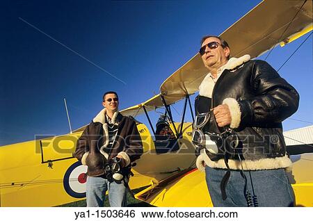 Two pilots with flying jackets near old British trainer biplane De Havilland DH 82a Tiger Moth used by the Royal Air Force View Large Photo Image Stock Photograph - Two pilots with flying jackets near old British trainer biplane De Havilland DH 82a Tiger Moth used by the Royal Air Force. Fotosearch