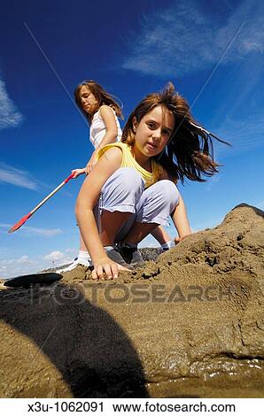 Two pre-teen sisters playing in the sun on the beach at Westward Ho in Devon England View Large Photo Image Stock Image - Two pre-teen sisters playing in the sun on the beach at Westward Ho in Devon England. Fotosearch