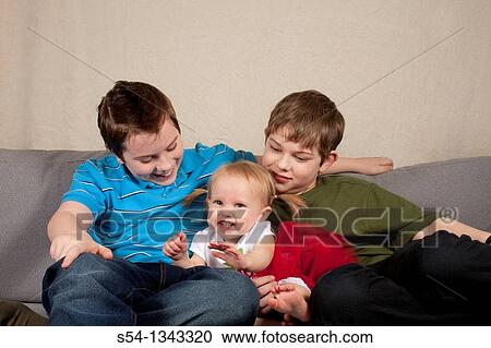 Two preteen brothers sitting with their toddler sister View Large Photo Image Stock Image - Two preteen brothers sitting with their toddler sister. Fotosearch