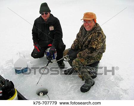 Stock Photo - Two seniors ice fishing. Fotosearch