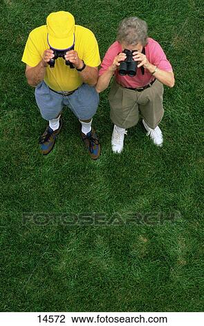 Two seniors looking through binoculars View Large Photo Image Stock Image - Two seniors looking through binoculars. Fotosearch