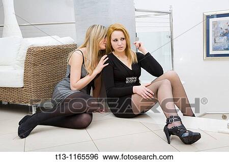 Two sexy female friends are talking sitting on the floor View Large Photo Image Stock Photograph - Two sexy female friends are talking sitting on the floor. Fotosearch