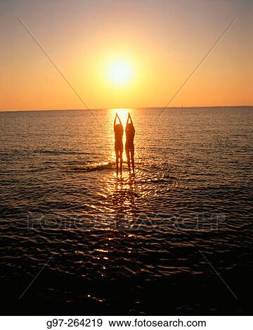 Two silhouettes at shoal in sunset View Large Photo Image Stock Photo - Two silhouettes at shoal in sunset. Fotosearch