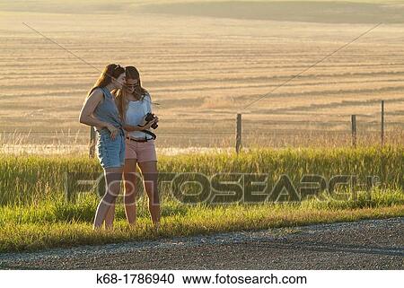 Two sisters, 16 and 20, stand by a country road in southern Alberta, Canada View Large Photo Image Stock Image - Two sisters, 16 and 20, stand by a country road in southern Alberta, Canada. Fotosearch