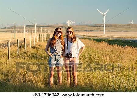 Stock Image - Two sisters, 16 and 20, stand in a field in southern Alberta, Canada. Fotosearch