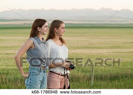 Two sisters, 16 and 20, stand near a field in southern Alberta, Canada View Large Photo Image Stock Photo - Two sisters, 16 and 20, stand near a field in southern Alberta, Canada. Fotosearch