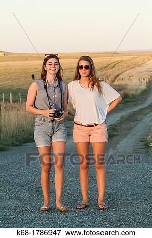 Two sisters, 16 and 20, stand on a road in southern Alberta, Canada View Large Photo Image Stock Photo - Two sisters, 16 and 20, stand on a road in southern Alberta, Canada. Fotosearch
