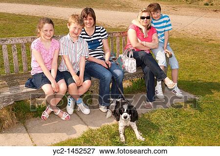 Two sisters and their three children and the dog on sitting on a bench in the Uk View Large Photo Image Stock Photo - Two sisters and their three children and the dog on sitting on a bench in the Uk. Fotosearch