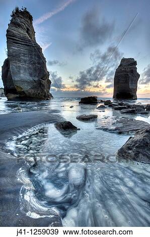 Stock Photo - Two Sisters formerly Three sisters until one rock stack fell over, sunset, Tongaporutu, North Taranaki.. Fotosearch