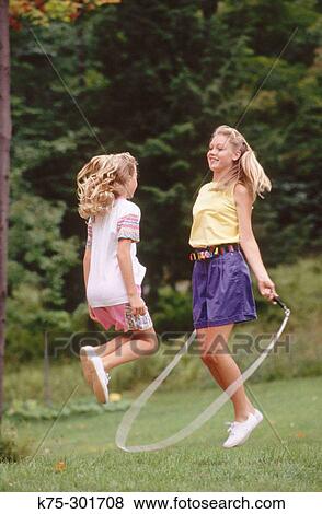 Stock Photo - two sisters jumping rope. Fotosearch