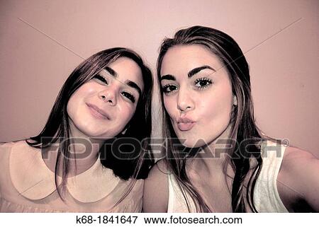 Stock Photo - two sisters pose for photos. Fotosearch