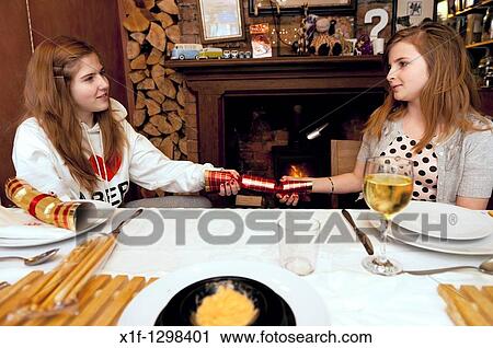 Two sisters pulling a cracker - A traditional British family christmas dinner at home, UK View Large Photo Image Stock Image - Two sisters pulling a cracker - A traditional British family christmas dinner at home, UK. Fotosearch