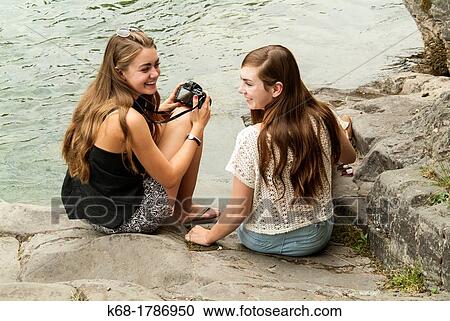 two sisters sit by a river View Large Photo Image Stock Image - two sisters sit by a river. Fotosearch