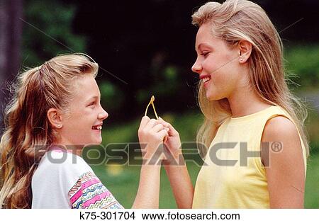 Picture - two sisters wishing on a wishbone. Fotosearch