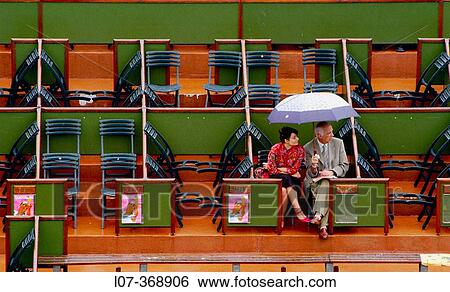 Two spectators under an umbrella at the French Open 2004. Paris. France View Large Photo Image Stock Photograph - Two spectators under an umbrella at the French Open 2004. Paris. France. Fotosearch