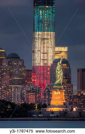Stock Photography - Two symbols of freedom, the Statue of Liberty and the Freedom Tower One World Trade Center, are illuminated at twilight in New York City.. Fotosearch