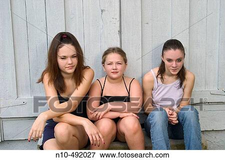 Two teen girls and their young sister sitting together View Large Photo Image Stock Photo - Two teen girls and their young sister sitting together. Fotosearch