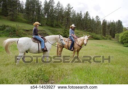 Stock Photo - Two teen girls riding horses in Reardan, Washington, USA.. Fotosearch