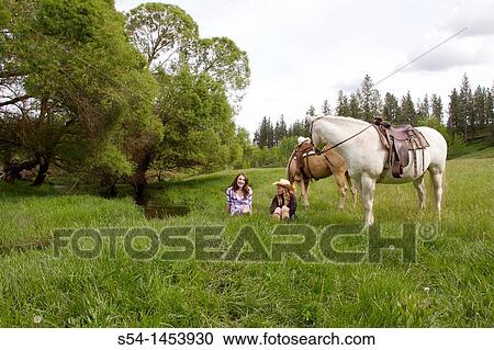 Two teen girls with horses in a field in Reardan, Washington, USA. View Large Photo Image Stock Image - Two teen girls with horses in a field in Reardan, Washington, USA.. Fotosearch