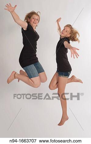 Two teenage girls Central European and jumping during a photo shoot. View Large Photo Image Stock Photo - Two teenage girls Central European and jumping during a photo shoot.. Fotosearch