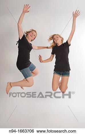 Two teenage girls Central European and jumping during a photo shoot. View Large Photo Image Stock Photograph - Two teenage girls Central European and jumping during a photo shoot.. Fotosearch
