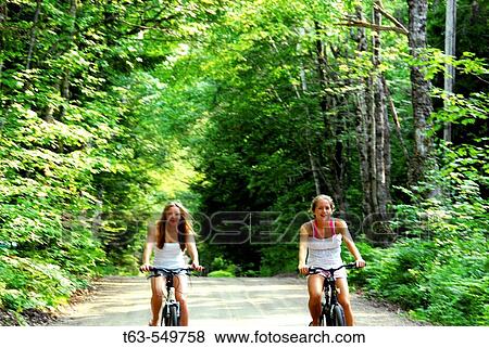 two teenage girls riding bikes together on country road View Large Photo Image Stock Photo - two teenage girls riding bikes together on country road. Fotosearch
