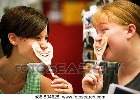 Two teenage girls with smiles on sticks View Large Photo Image Stock Photography - Two teenage girls with smiles on sticks. Fotosearch