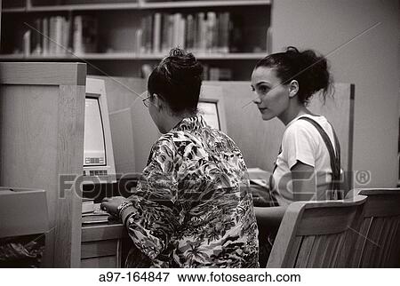 Two teenagers using computers in library View Large Photo Image Stock Photo - Two teenagers using computers in library. Fotosearch