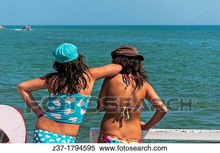Two teenagers watch a boat on Lake Erie, Ontario, Canada View Large Photo Image Stock Photography - Two teenagers watch a boat on Lake Erie, Ontario, Canada. Fotosearch