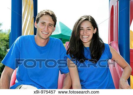 Two teens together on a slide smiling View Large Photo Image Stock Photo - Two teens together on a slide smiling. Fotosearch