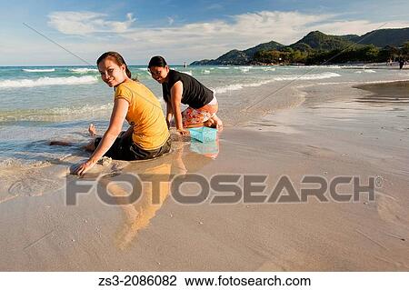 Two Thai women sitting on the beach, Chaweng, Koh Samui, Surat Thani Province, Thailand. View Large Photo Image Stock Image - Two Thai women sitting on the beach, Chaweng, Koh Samui, Surat Thani Province, Thailand.. Fotosearch