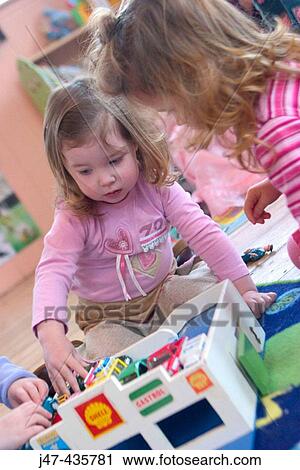 Two three year old girls playing with cars on the floor View Large Photo Image Stock Image - Two three year old girls playing with cars on the floor. Fotosearch