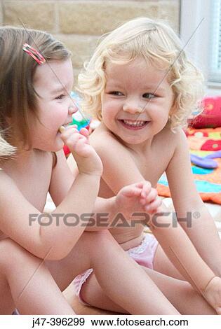 Two three year old girls sitting on the floor, in only pants, laughing View Large Photo Image Stock Photo - Two three year old girls sitting on the floor, in only pants, laughing. Fotosearch